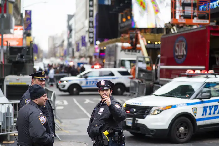 Three NYPD officers stand in Times Square.